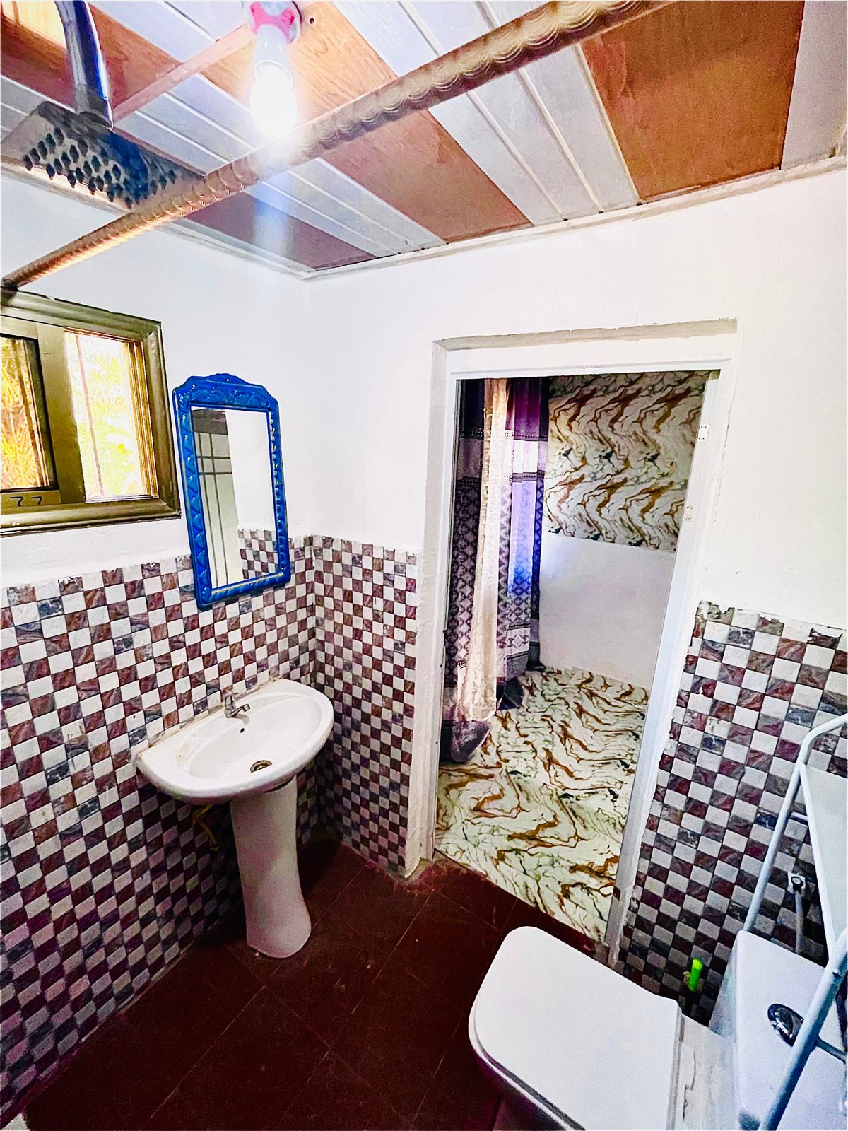 Private bathroom with tiled walls and sink